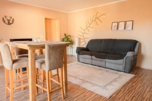 a living room with a table and a leather couch at FeWo Böhaming in Schaufling