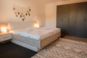 a bedroom with a large bed and a rug at FeWo Böhaming in Schaufling