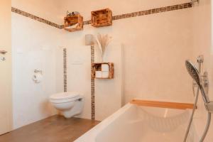 a bathroom with a toilet and a bath tub at FeWo Böhaming in Schaufling