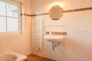 a bathroom with a sink and a mirror and a window at FeWo Böhaming in Schaufling