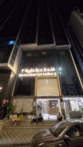 a group of people sitting on steps outside of a building at فندق درة طيبة 3 in Az Zahrāʼ