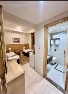 a hotel room with a bedroom and a bathroom at فندق درة طيبة 3 in Az Zahrāʼ +28 photos