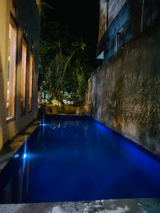 a pool of blue water in a courtyard at night at WLA Homestay in Labuan Bajo