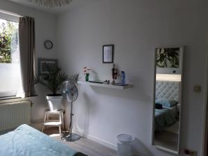 a white bedroom with a mirror and a bed at Zen Olive Guest Room in Antwerp