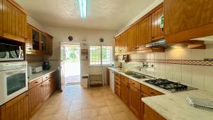 a kitchen with wooden cabinets and a stove top oven at Sol - Private Pool - 14 Guests - Vilamoura in Vilamoura