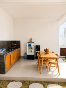 a kitchen with a wooden table and a refrigerator at Padmasari Guest House in Canggu