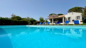 a swimming pool with blue chairs and a house at Sol - Private Pool - 14 Guests - Vilamoura in Vilamoura