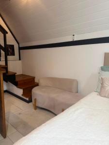 a room with a bed and a couch and a chair at Chalé do amor, sítio pousada vô Maneca in Timbó