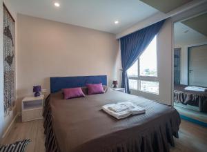 a bedroom with a bed with pink pillows and a window at 7Seas in Jomtien Beach +75 photos