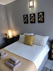 a bedroom with a bed with three pictures on the wall at Wildebeespan Guest Farm in Delareyville