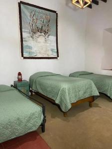 a room with three beds and a painting on the wall at Casa xocolatl in San Miguel de Allende +4 photos