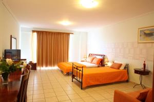 a hotel room with a bed and a television at Grand Resort nefeli in Vasiliki