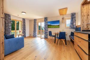 a living room with a blue couch and a table at Landhaus Lengg in Reit im Winkl