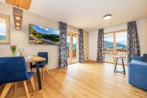 a living room with a table and blue chairs at Landhaus Lengg in Reit im Winkl