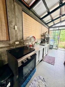 a kitchen with a stove and a sink in it at TeamV Kubo Guesthouse in Agdañgan