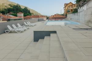 a swimming pool on a roof with lounge chairs at Termas do Gerês Studio in Geres