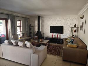 a living room with two couches and a flat screen tv at Stay & unwind in Alberton