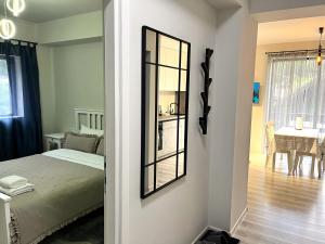 a bedroom with a mirror and a dining room at Mountain Stream Serenity - AC and Free Parking in Buşteni