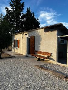 a small building with a bench in front of it at Maisonnette et Campagne Provençale, avec Piscine in Orgon