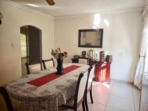a dining room table with a vase of flowers on it at Stay & unwind in Alberton