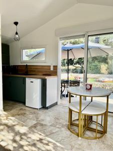 a kitchen with a table and an umbrella at Maisonnette et Campagne Provençale, avec Piscine in Orgon