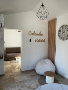 a living room with a couch and a clock on the wall at Maisonnette et Campagne Provençale, avec Piscine in Orgon