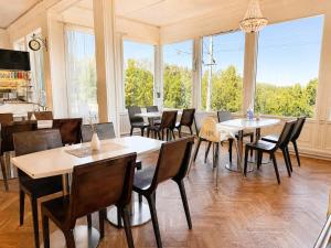 a dining room with tables and chairs and windows at B&B Carl XII in Ed