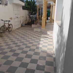 a bike parked on a checkered floor in a house at Grande maison de vacances 250m2 in Rejiche