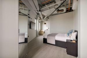 a bedroom with a bed in a room with white walls at Diff-Rent Studios with gym & Fast Access to Central London & Wembley in Harrow