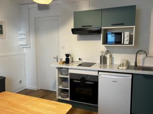 a kitchen with a sink and a stove top oven at La Parenthèse Meymacoise in Meymac