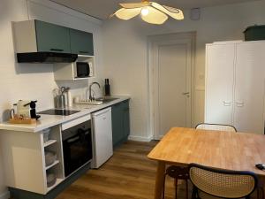a kitchen with green cabinets and a wooden table at La Parenthèse Meymacoise in Meymac