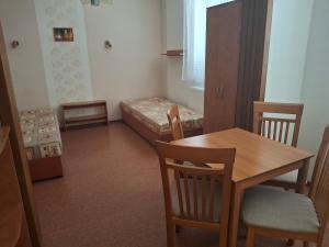 a small room with a table and chairs and a bed at penzion BON TRE in Třeboň
