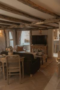 a living room with a couch and a tv at Hathaway Hamlet in Stratford-upon-Avon