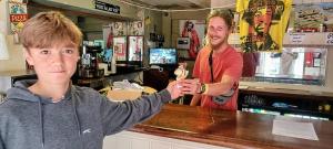 a man standing at a bar with a boy at First and Last Youth Hostel in Dover