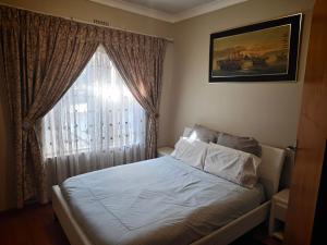 a bedroom with a bed with a window at Stay & unwind in Alberton