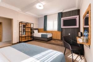 a hotel room with a bed and a television at Хотел EFES in Burgas +25 photos