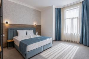 a hotel room with a bed and a window at Хотел EFES in Burgas