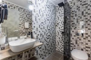 a bathroom with a sink and a toilet at Хотел EFES in Burgas