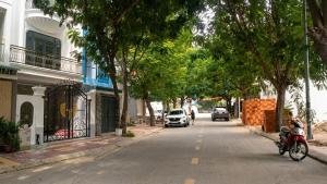 a street with cars driving down a street with trees at Mai Song Linh in Phan Rang–Tháp Chàm