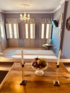 a room with a bed with a bowl of fruit on a table at Symi Aerides Suites in Symi