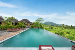 a swimming pool in a villa with chairs and trees at ArtVilla Sidemen River in Sidemen