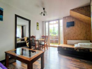 a living room with a table and a couch and a table at Pokoje Gościnne Barka - 300m do RESTAURACJI - 900m do JEZIORA i VELO CZORSZTYN in Kluszkowce