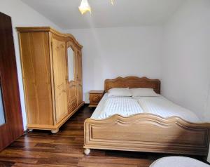 a bedroom with a wooden bed and a wooden dresser at Pokoje Gościnne Barka - 300m do RESTAURACJI - 900m do JEZIORA i VELO CZORSZTYN in Kluszkowce