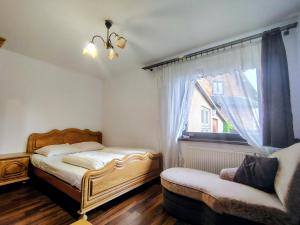 a bedroom with a bed and a couch and a window at Pokoje Gościnne Barka - 300m do RESTAURACJI - 900m do JEZIORA i VELO CZORSZTYN in Kluszkowce +75 photos
