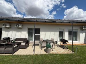 a patio with a table and chairs and a grill at Local-Lux Garden Residence A- 2 Bedrooms-Terrace in Kecskemét