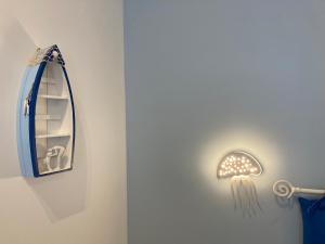 a light with a jellyfish on the wall next to a mirror at Tra Cielo e Mare - Monopoli in Impalata