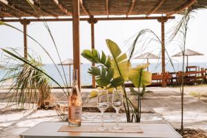 a table with two glasses and a bottle of wine at Burano Camping Beach-Bar in Néa Thésis
