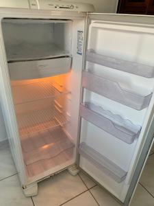 an empty refrigerator with its door open in a kitchen at Fortal Flat in Fortaleza