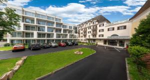 an apartment complex with cars parked in a parking lot at Pytloun Schlosshotel Weikersdorf in Baden