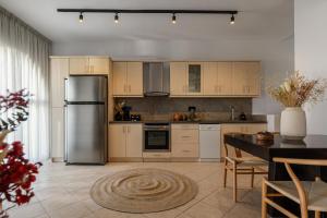 a kitchen with a stainless steel refrigerator and a table at Villa Irina in Agios Prokopios